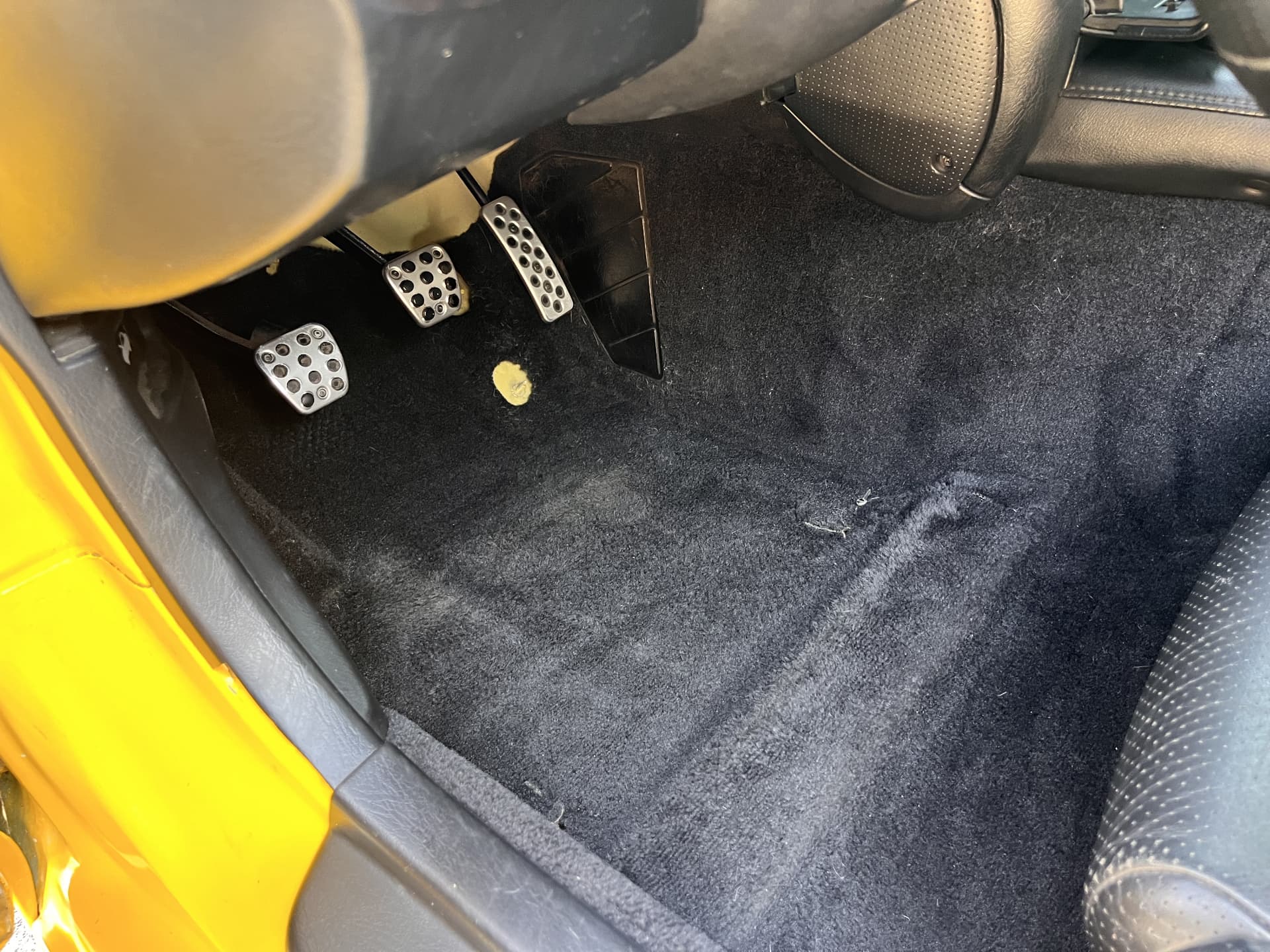 Clean black driver footwell and carpet after interior detailing