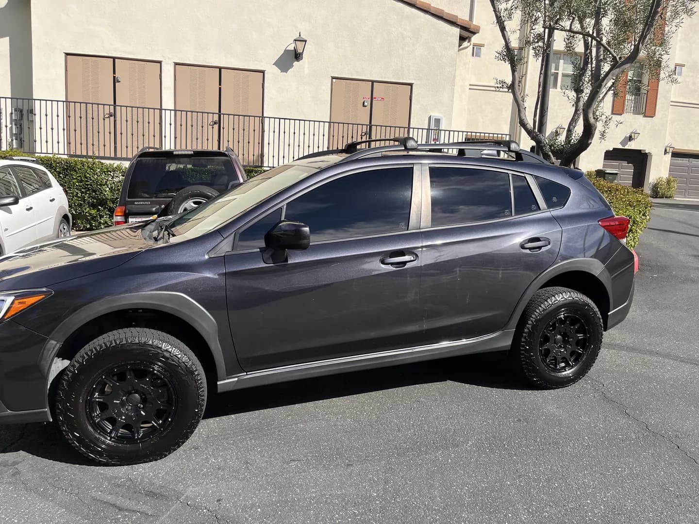Gray Subaru crossover with a roof rack and black wheels