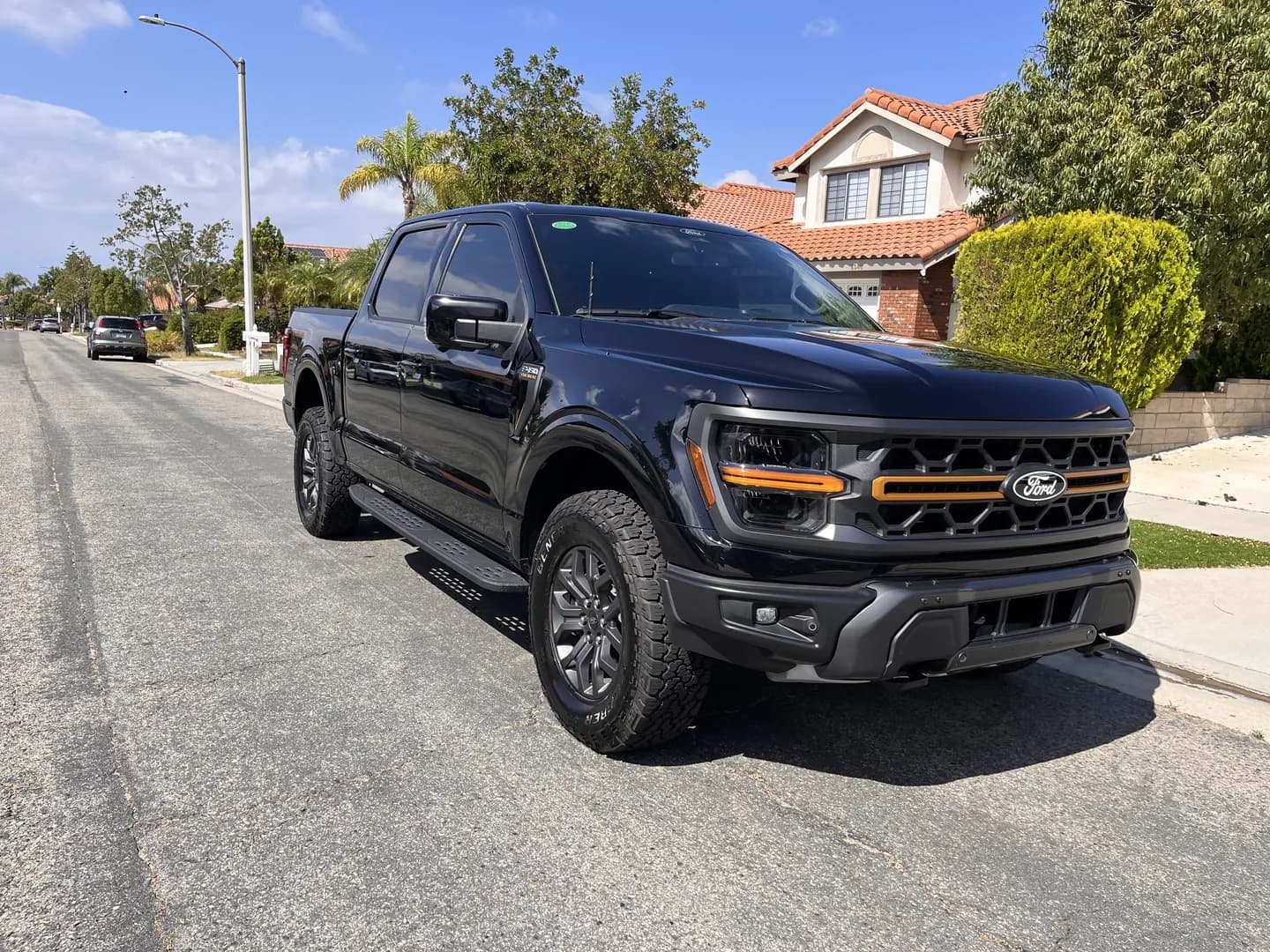 Black Ford pickup viewed from the front corner