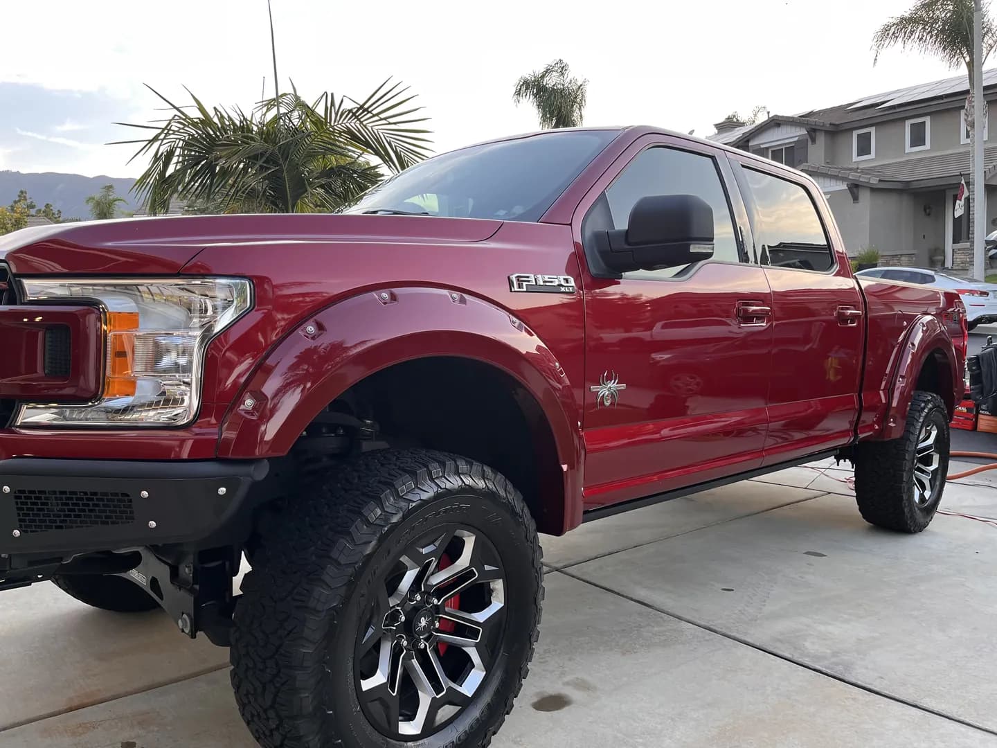 Red Ford pickup with large off-road wheels